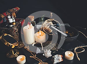 Witch`s working space. A very messy witch`s altar filled with random tidbits like mortar and pestle, burning white candles photo