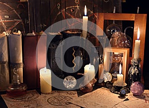 Witch table with magic objects, candles and old mystic parchments