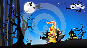 Witches dancing around fire at halloween