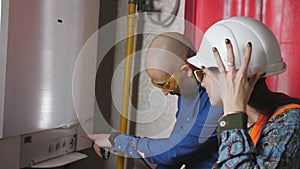 Withdrawal and readings of pressure and temperature in the boiler room of a female supervisor and a male engineer.