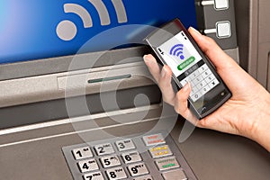 withdrawing money atm with mobile phone (NFC near field communication) photo