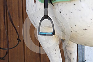 A withe horse saddle stirrup that is ready to be mounted