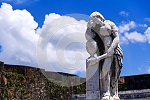 Withered Statue Leaning Against a Grave