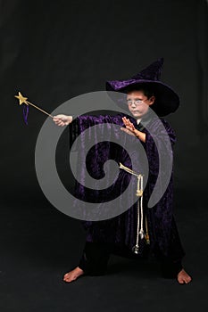 Wizard boy with magic wand casting a spell photo