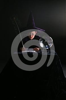Wizard boy writing a spell