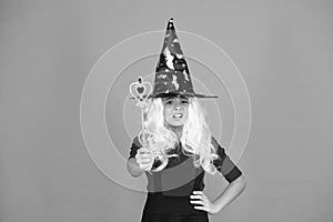 Wizard with stick. Having fun with magic. Little child in witch costume. Halloween party. Small girl in black witch hat