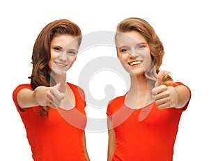 Wo teenage girls in red t-shirts showing thumbs up