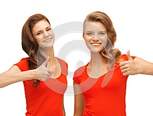 Wo teenage girls in red t-shirts showing thumbs up