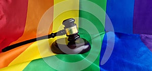 Woden judge gavel symbol of law and justice with lgbt flag in rainbow colors safety and protection