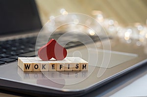 WOKEFISH online dating concept letter blocks on laptop keyboard