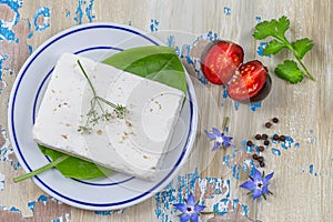 Wole Feta cheese isolated on white background clipping Heap of Feta cheese, basil leaves and tomatoes.