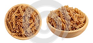 Wolegrain fusilli pasta from durum wheat in wooden bowl isolated on white background with full depth of field. Top view