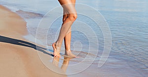 WomÐ°n feet in the water on the sea coast