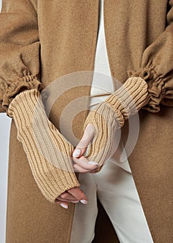 WomÐ°n hands in warm winter mittens gloves. Autumn clothing. Beautiful nail manicures