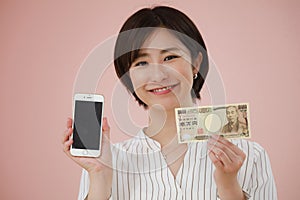 A woman with a 10,000 yen note and a smartphone