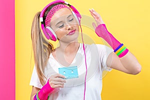 Woman in 1980`s fashion holding a cassette tape