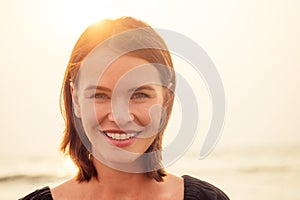 Woman, 30-35 years old smiling toothy smile with braces on sea ocean beach background.spf and sunscreen