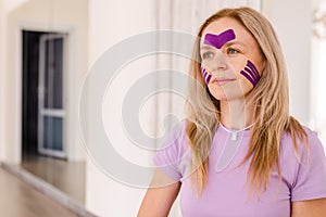 woman 30 -40 years old applying lifting tape . concept of facial rejuvenation, Kinesiotaping for face.