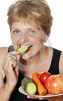 Woman (67 years old) eating vegetables