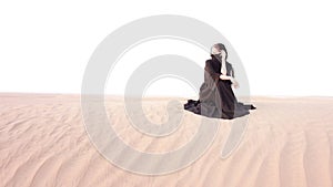 A woman in abaya walking in the desert. photo