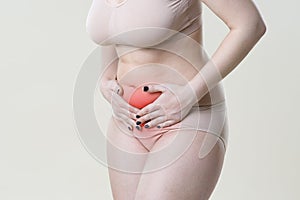 Woman with abdominal pain, stomachache on beige background