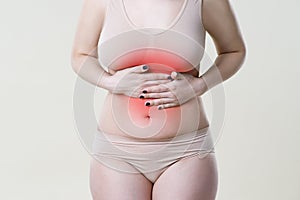 Woman with abdominal pain, stomachache on beige background
