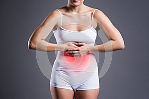 Woman with abdominal pain, stomachache on gray background