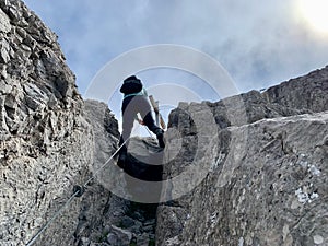 Woman abseiling from peak in Austrian Alps. Vorarlberg, Austria.