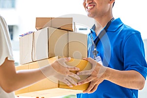 Woman accepting a delivery of cardboard boxes from deliveryman