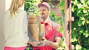 Woman accepting a home delivery of boxes from deliveryman