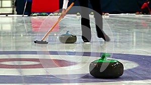 Woman accompanies the curling stone on the ice.