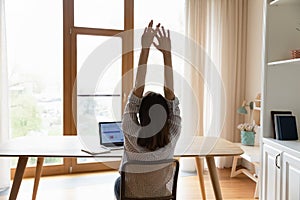 Woman accomplish work lean on chair with raised arms