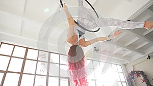 Woman acrobat on the hula hoop In the white background