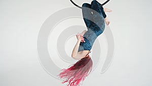 Woman acrobat on the hula hoop In the white background