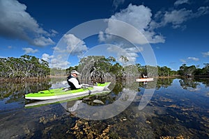 Woman and active senior kayaking on Nine Mile Pond in Everglades National Park.