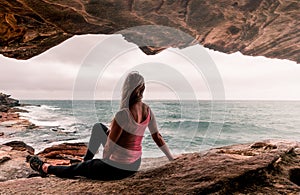 Woman in activewear sitting by the ocean