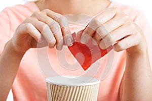 Woman Adding Artificial Sweetener To Coffee