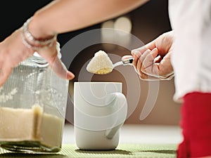 Woman Adding Lots Of Sugar With Teaspoon To Coffee Mug