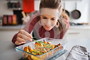 Woman adding rosmarinus to baked pumpkin. Closeup photo