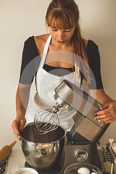 Woman adds some flour to dough on wooden table. Woman hands kneading fresh dough.