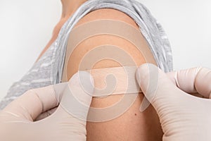 Woman with adhesive bandage on her shoulder