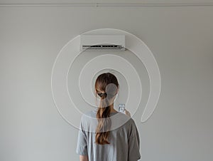 Woman Adjusting Air Conditioner Temperature