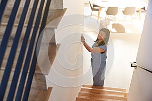 Woman Adjusting Digital Central Heating Thermostat At Home