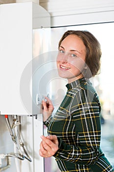 Woman adjusting gas water heater