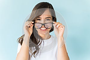 Woman Adjusting Her Eyeglasses Over Plain Background