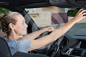 Woman adjusting rear-view mirror car