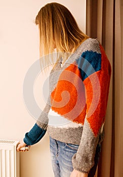 Woman adjusting temperature of home heater.