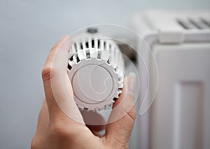 Woman Adjusting The Thermostat