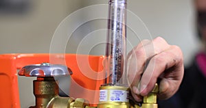 Woman adjusting welding machine pressure gauge