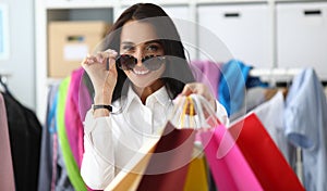 Woman adjusts glasses from sun showing packages